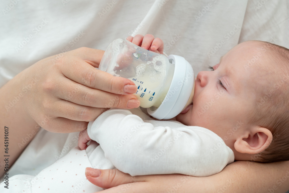 Newborn baby sips milk formula, Concept of nurturing and maternal bond Newborn baby sips milk formula, Concept of nurturing and maternal bond
