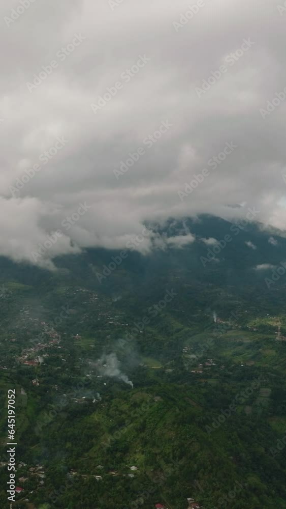 Aerial drone of mountains with green forests and agricultural land with farm plantations. Bukittinggi, Sumatra. Indonesia. Aerial drone of mountains with green forests and agricultural land with farm plantations. Bukittinggi, Sumatra. Indonesia.
