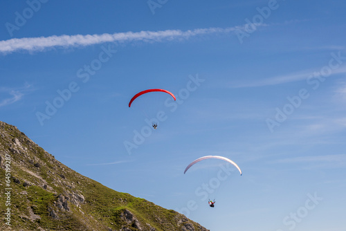 Two men paragliding over the top of Innsbruck in Tyrol, Austria in summer