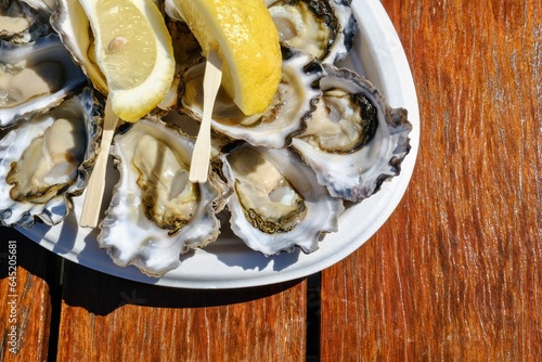 A plate of fresh Sydney rock oysters with lemon wedges on a sunny morning at Jim Wilds Oyster Shack, Greenwell Point, NSW photo