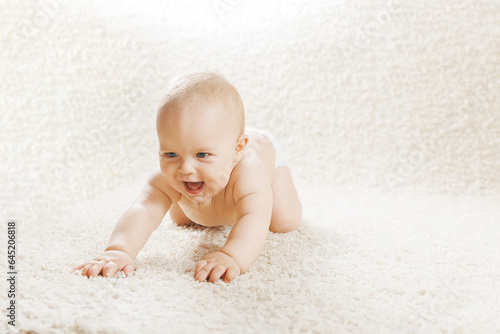 Happy baby boy crawling indoors at home on white background. Concept first step