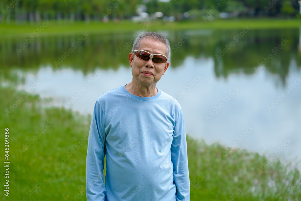 Happiness in nature, elderly asian man in blue shirt blissful time in the park, nature's comfort, parkside relaxation, peaceful moments, refreshing break Happiness in nature, elderly asian man in blue shirt blissful time in the park, nature's comfort, parkside relaxation, peaceful moments, refreshing break