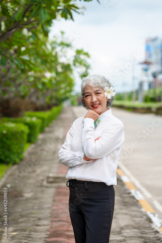 Happy mature asian woman with grey hair relaxing in park, senior serenity, refreshing break, happy mature lady enjoys relaxation at the park, breathfresh