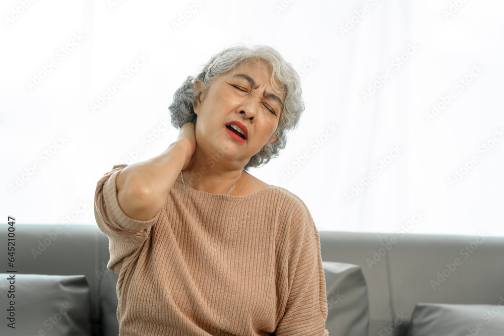 Elderly asian woman sitting on the couch, neck pain. Elderly asian woman sitting on the couch, neck pain.