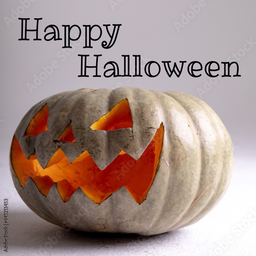 Composite of happy halloween text and halloween pumpkin on grey background