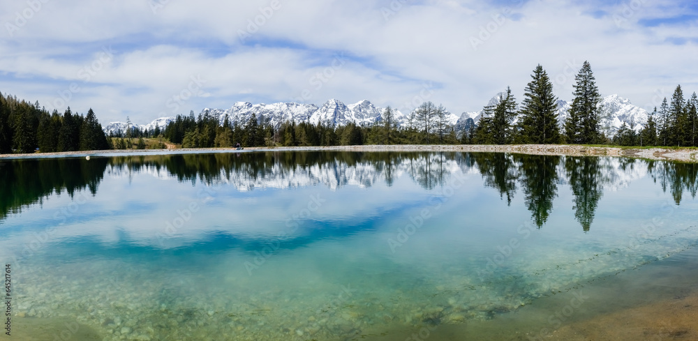 wonderful landscape with snowy mountain range and a lake with reflections panorama