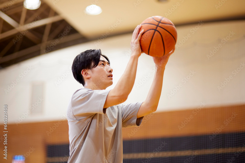 © west_photo - 体育館でバスケットボールの練習をする日本人大学生の男性