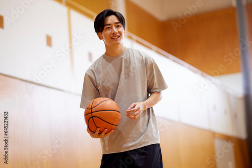 体育館でバスケットボールの練習をする日本人大学生の男性 © west_photo