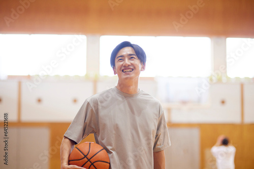 体育館でバスケットボールの練習をする日本人高校生の男性 photo