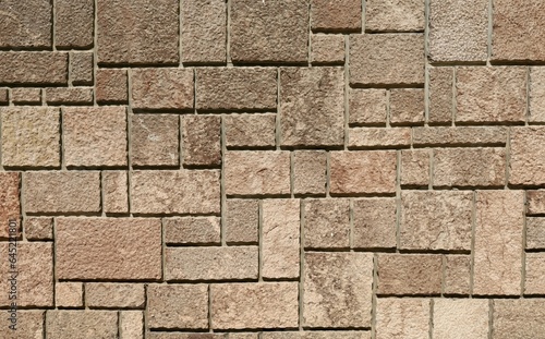 Rough stone tiles, granite texture, for exterior wall. Colors are brown and pink. Background and texture.	