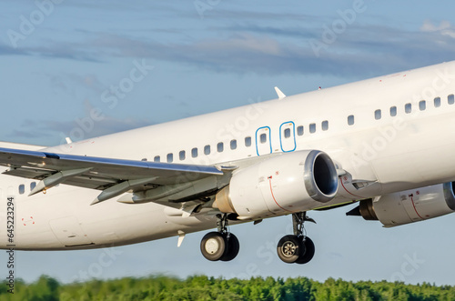 Airliner jet white plane take off in the air on tree background