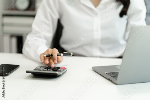 Hand women doing finances and calculate on desk about cost at home office.