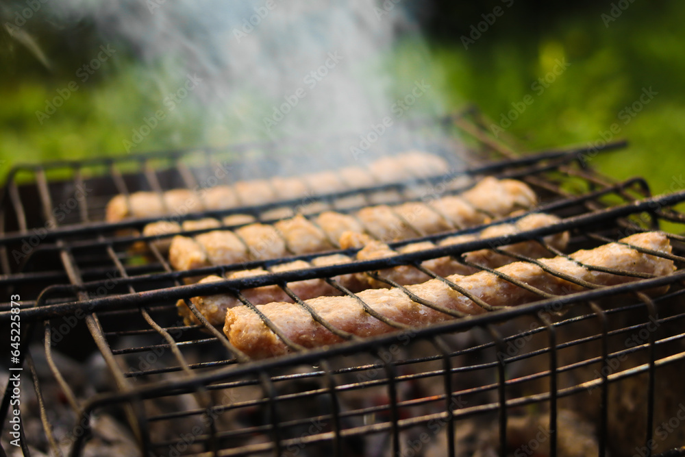 Meat sausages are grilled. Picnic in nature. Close-up. Selective focus. Copyspace