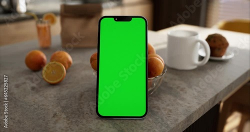 Smartphone place on kitchen table, Green screen telephone, Close up display mobile phone with mock up, Chroma key monitor