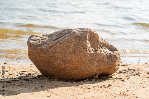 Large stone on the shore on a sunny summer day, close-up