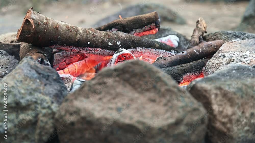 Close-up of bonfire burning in a hearth made of stones outdoors
