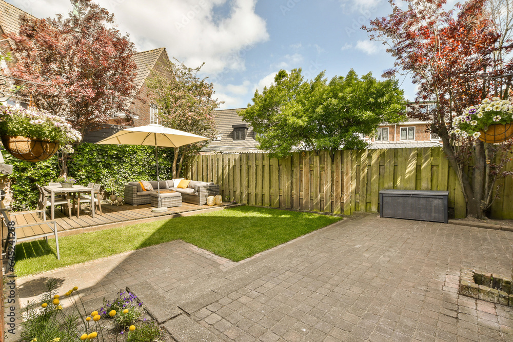 a backyard area with a table, chairs and an umbrella in the middle part of the yard is surrounded by trees