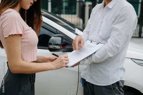 Customers and car insurance agents have entered into agreements and signed documents to claim compensation after on the road in sun light.. photo