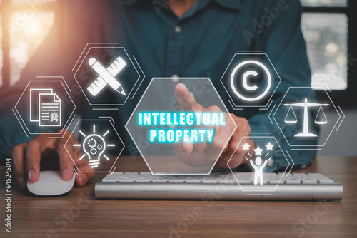 Intellectual property concept, Businessman hand touching Intellectual property icon on virtual screen.