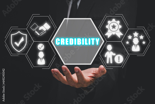 Corporate credibility improvement concept, Business person hand holding credibility icon on virtual screen.