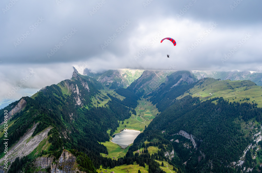 Altstatten, Switzerland - July 4, 2023: A paraglider circles the top of the Hoher Kasten mountain Altstatten, Switzerland - July 4, 2023: A paraglider circles the top of the Hoher Kasten mountain