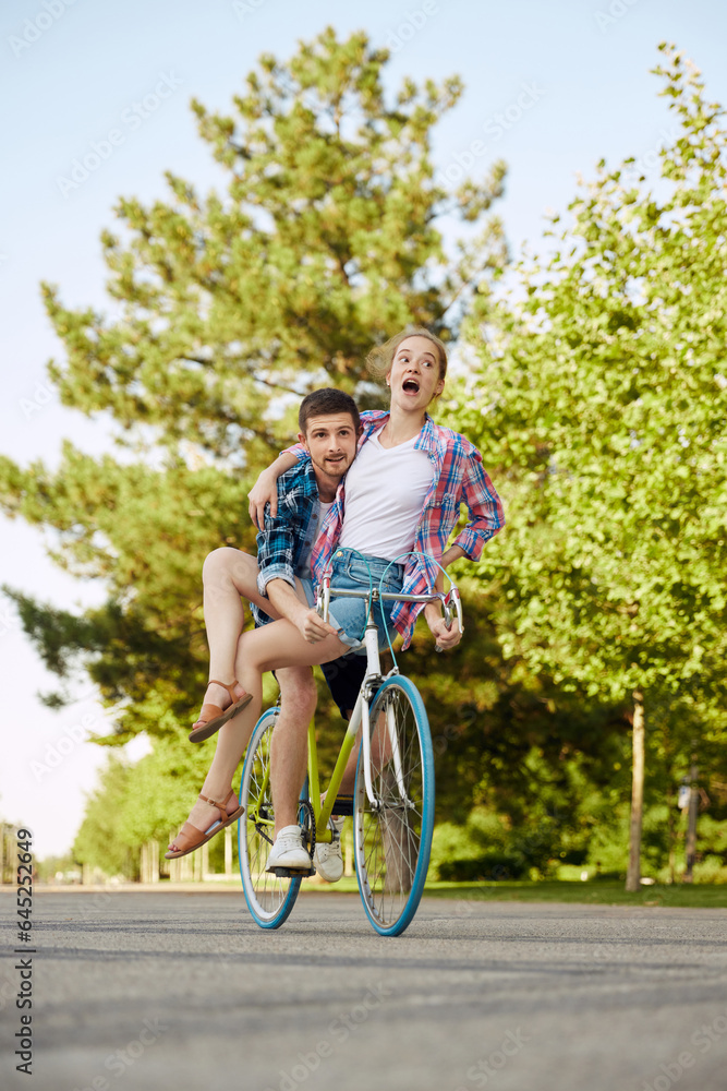 Adventures together. Couple in love riding bicycle. Handsome guy and young sensual woman travel. Youthful riders enjoying themselves on trip.