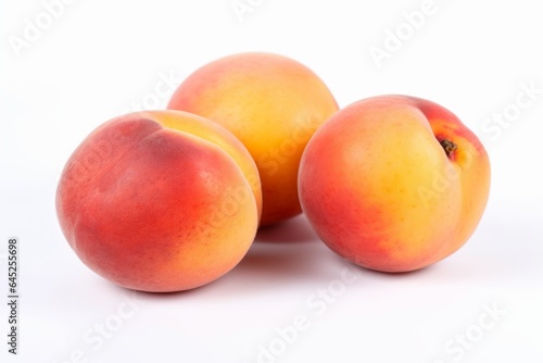 Three ripe peaches on a clean white background