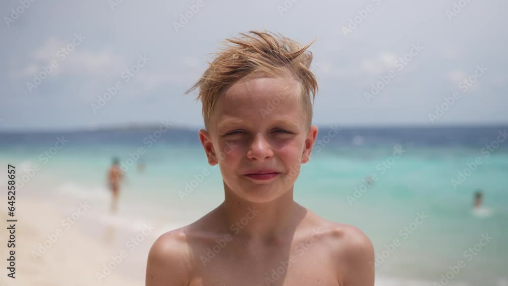 Happy caucasian child boy greeting hand wave to say hi on the beach during summer vacation, video portrait. High quality 4k footage Happy caucasian child boy greeting hand wave to say hi on the beach during summer vacation, video portrait. High quality 4k footage