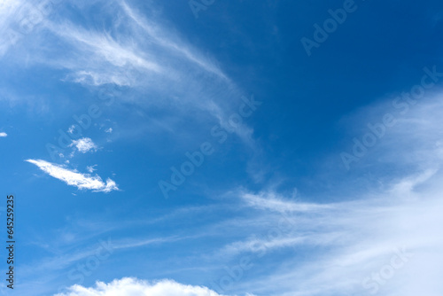 Abstract flowing cloudscape against blue sky background.
