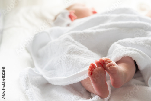 Newborn's tender moments wrapped in white. Concept of post-bath comfort and warmth