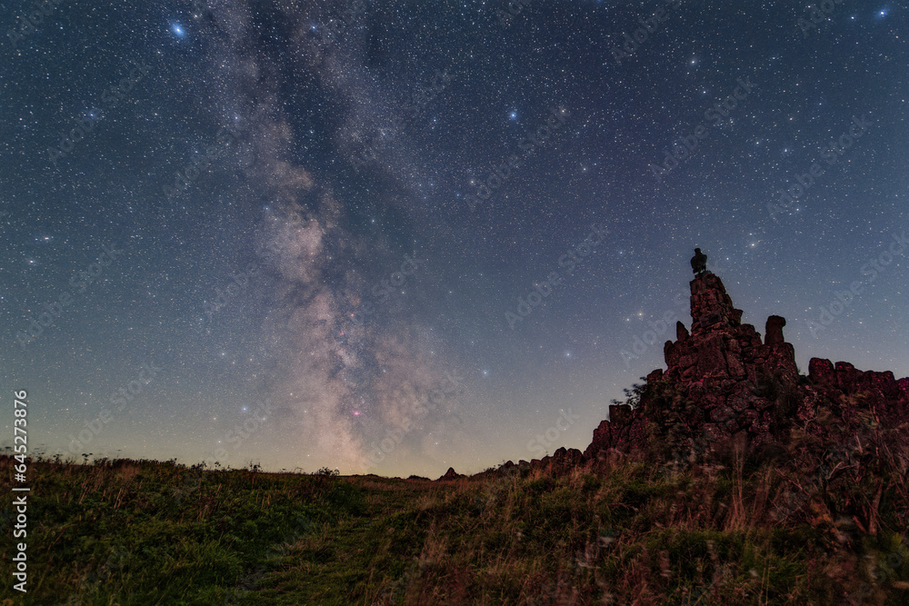 The Milky Way over the summit of the mountain Wasserkuppe in the Rhoen in Germany. - obrazy, fototapety, plakaty 