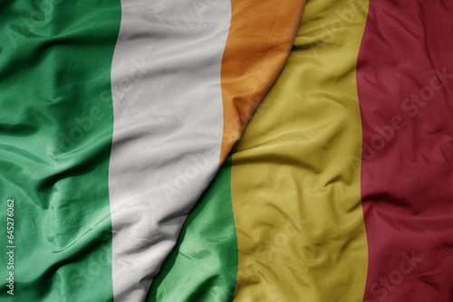 big waving national colorful flag of ireland and national flag of mali .