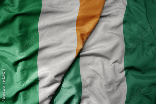 big waving national colorful flag of ireland and national flag of nigeria .