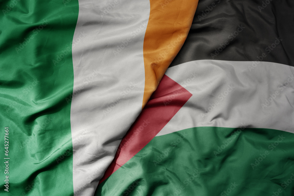 big waving national colorful flag of ireland and national flag of palestine .