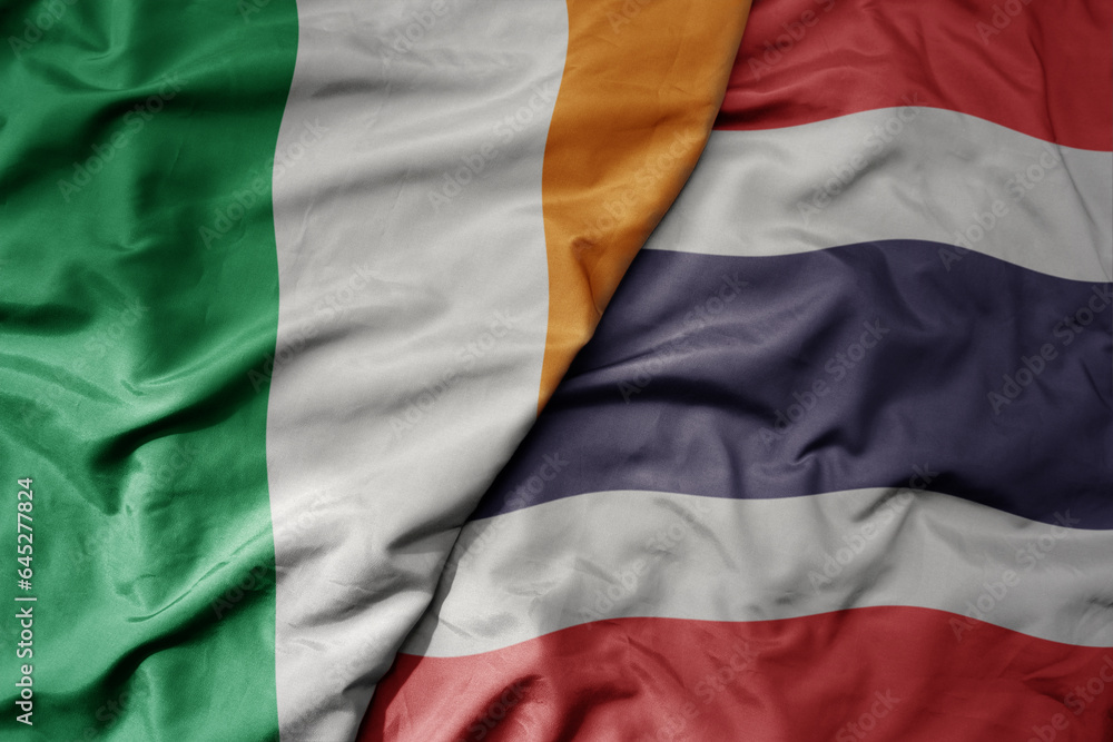 Obraz premium big waving national colorful flag of ireland and national flag of thailand .