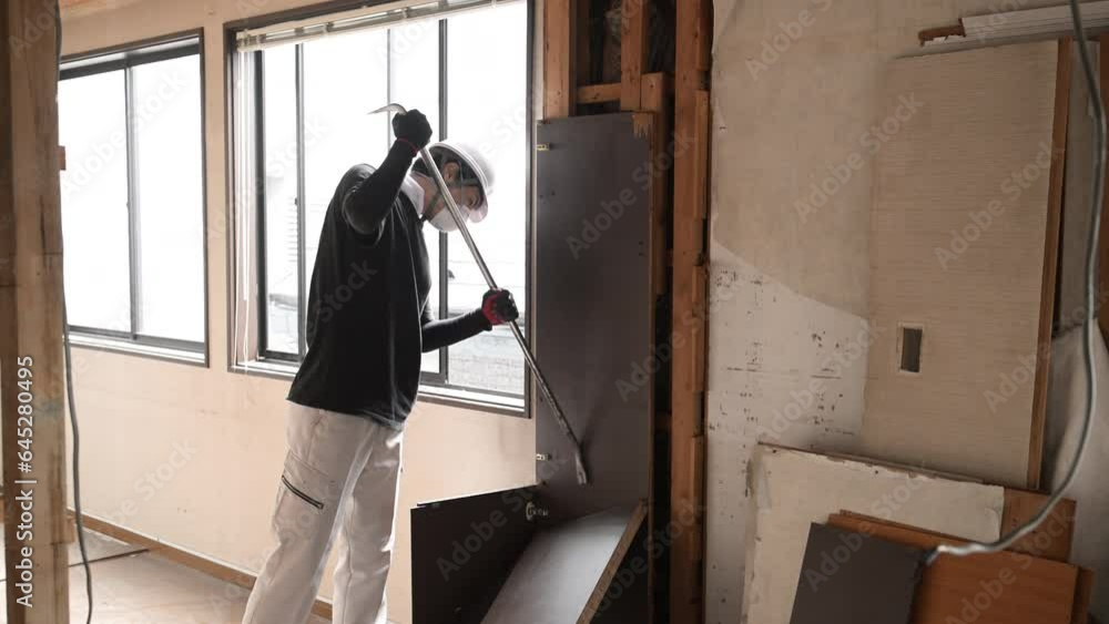 建築現場で働く若いマスクの作業員 内装の解体の動画 バールで壁を壊す 建築現場で働く若いマスクの作業員 内装の解体の動画 バールで壁を壊す