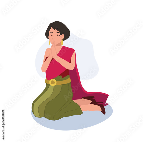 Thai Culture concept. Thai woman in traditional dress is sitting and praying , making wai. Praying Gesture