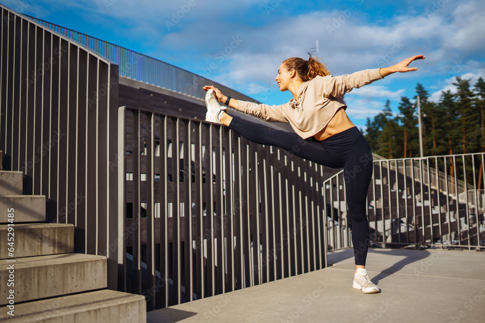 Fitness woman doing sports outdoors in an urban environment. A sports woman in special clothes does exercises. Active lifestyle, training. Lifestyle.