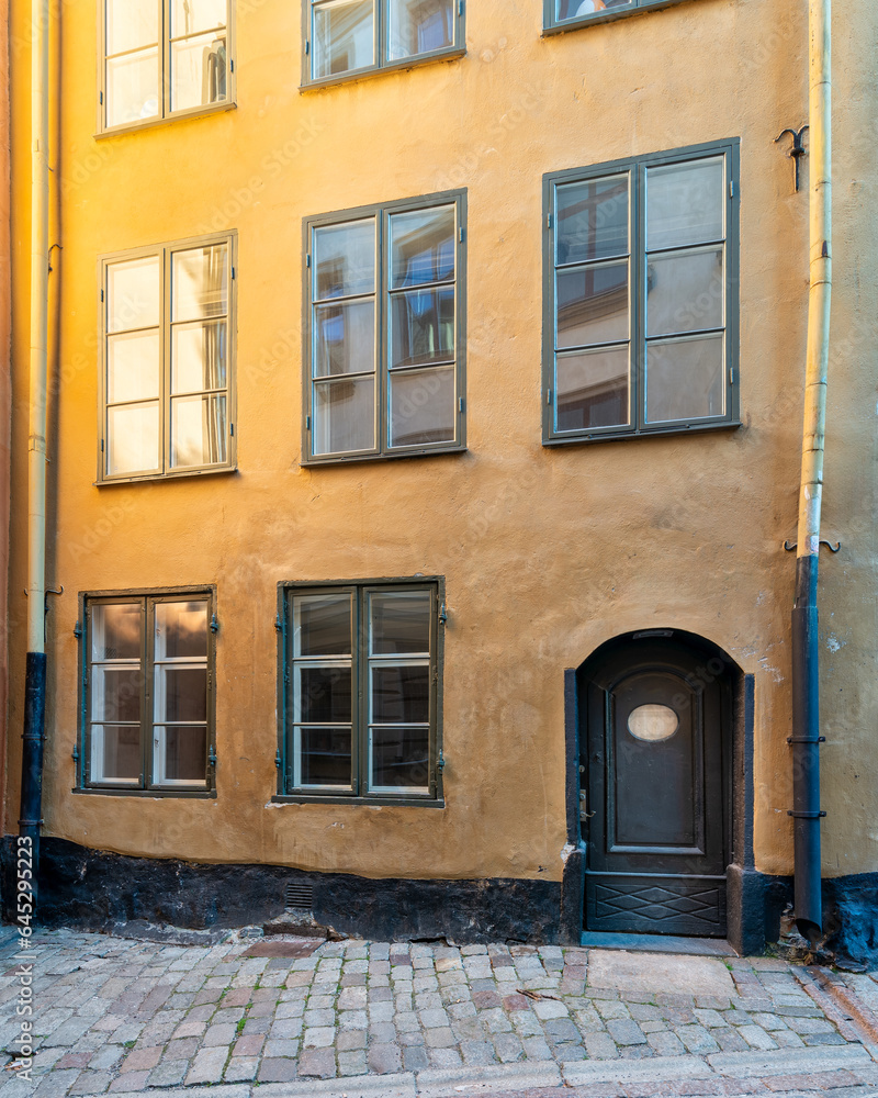 Narrow alley in Gamla stan, the old town of Stockholm, Sweden, with old style orange colored house and cobblestone street, Stockholm, Sweden Narrow alley in Gamla stan, the old town of Stockholm, Sweden, with old style orange colored house and cobblestone street, Stockholm, Sweden