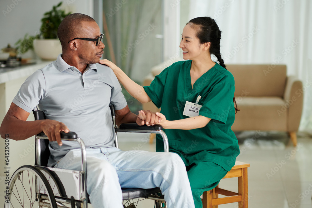 Positive social worker visiting patient at home to take care and give support Positive social worker visiting patient at home to take care and give support