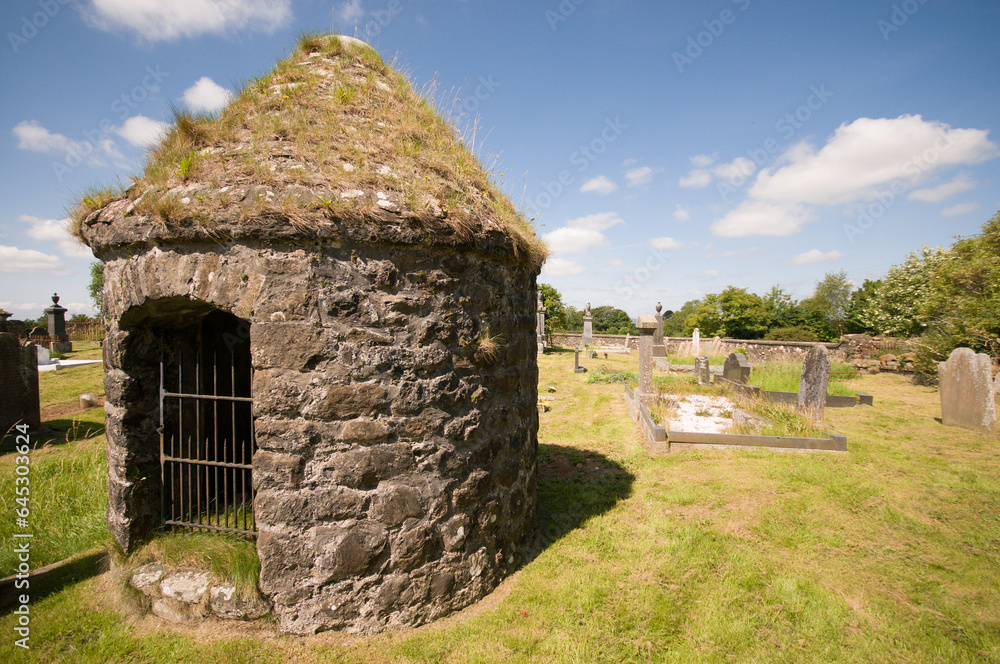 Round stone burial chamber with stone roof in a graveyard Round stone burial chamber with stone roof in a graveyard