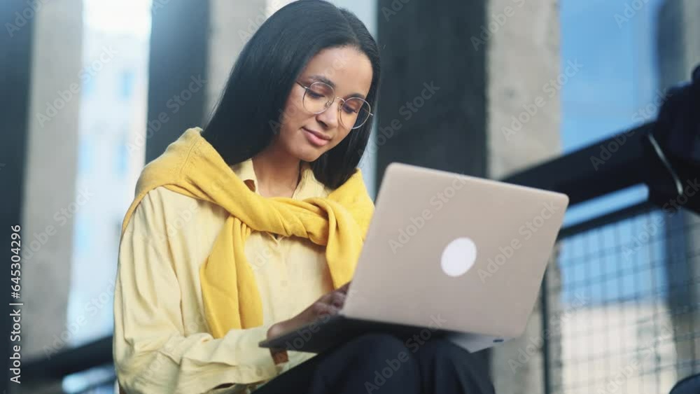 Pretty young woman freelancer or student working on laptop and looking at screen at modern university Busy girl having distance remote freelance work or education on computer outdoors Pretty young woman freelancer or student working on laptop and looking at screen at modern university Busy girl having distance remote freelance work or education on computer outdoors