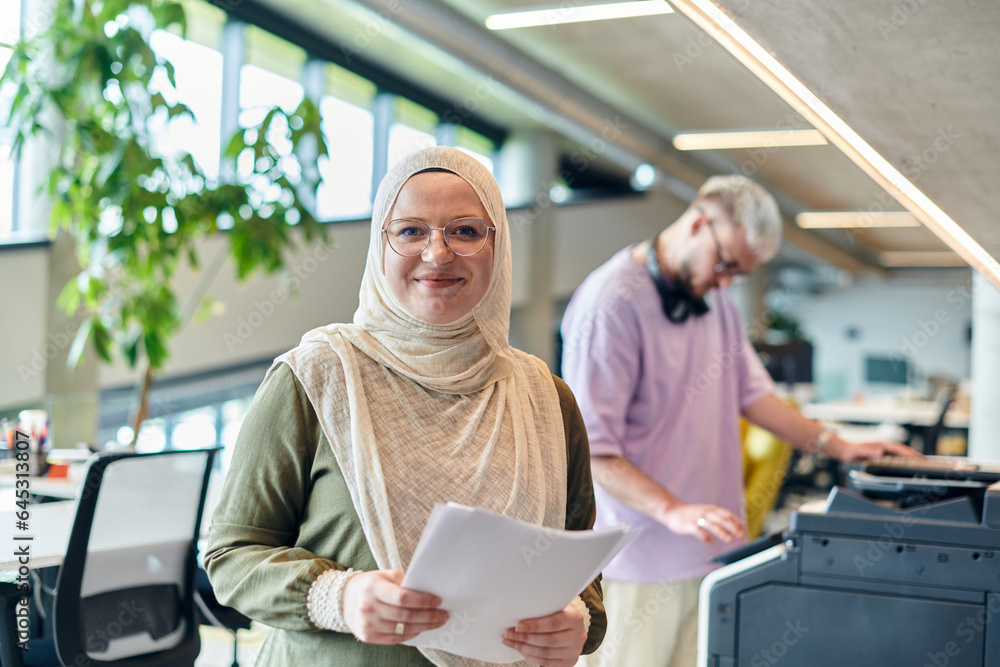 In a modern startup office, a business-minded Muslim woman wearing a hijab collaborates with her colleague, symbolizing diversity, empowerment, and success in the contemporary corporate world In a modern startup office, a business-minded Muslim woman wearing a hijab collaborates with her colleague, symbolizing diversity, empowerment, and success in the contemporary corporate world
