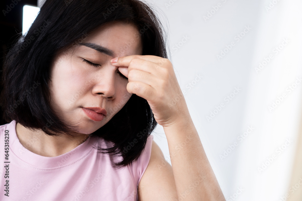 asian woman suffering from pain between eyebrows and eyes caused by headache, sinus infection asian woman suffering from pain between eyebrows and eyes caused by headache, sinus infection