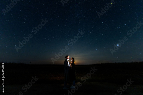 silhouettes of a couple in love at night against the backdrop of the night starry sky, romantic date