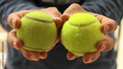 manos sujetando dos pelotas de tenis © Manuel
