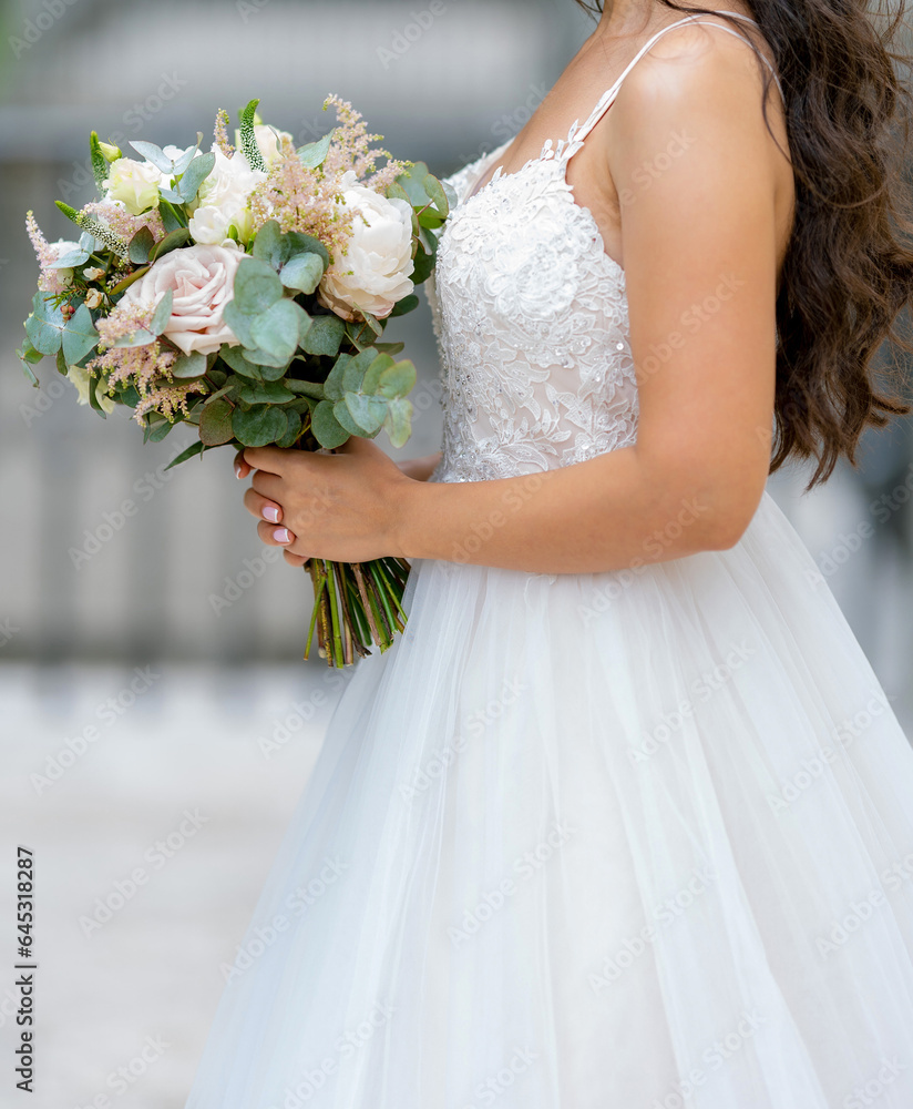 Naklejka premium Bride holds the wedding bouquet of flowers
