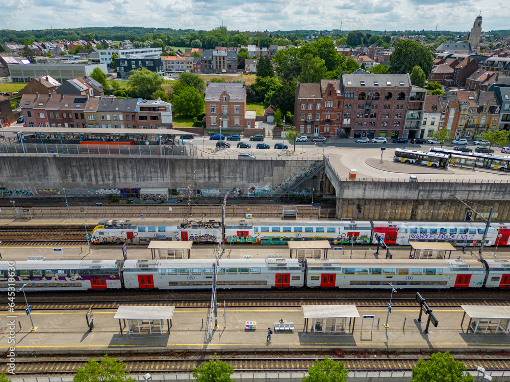Halle, Flemish Brabant Region, Belgium, 01 05 2023, aerialview of the railway station in the city of Halle on a sunny spring day, showing the Belgian trains on the tracks at the platforms. High