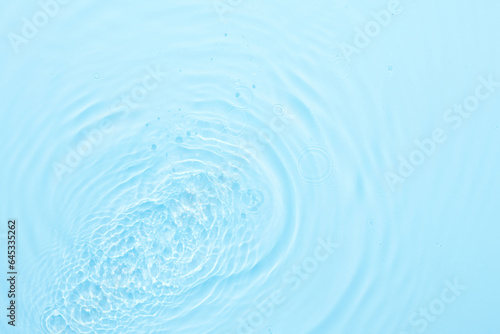 Water blue surface abstract background. Waves and ripples texture of cosmetic aqua moisturizer with bubbles