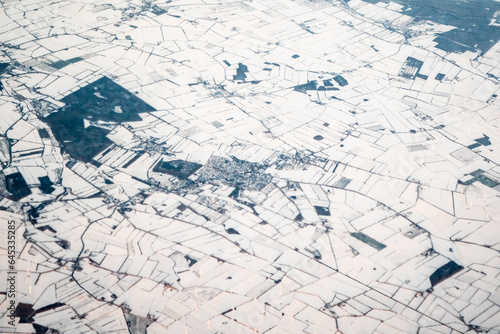 Aerial view over snowy fields and town from airplane